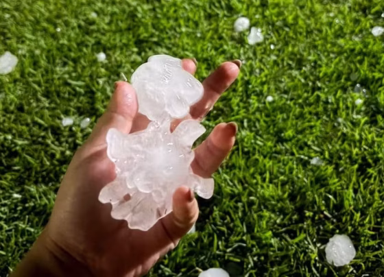 Moradora mostra tamanho das pedras de gelo após temporal em Deodápolis - Foto: Susi Reginato
